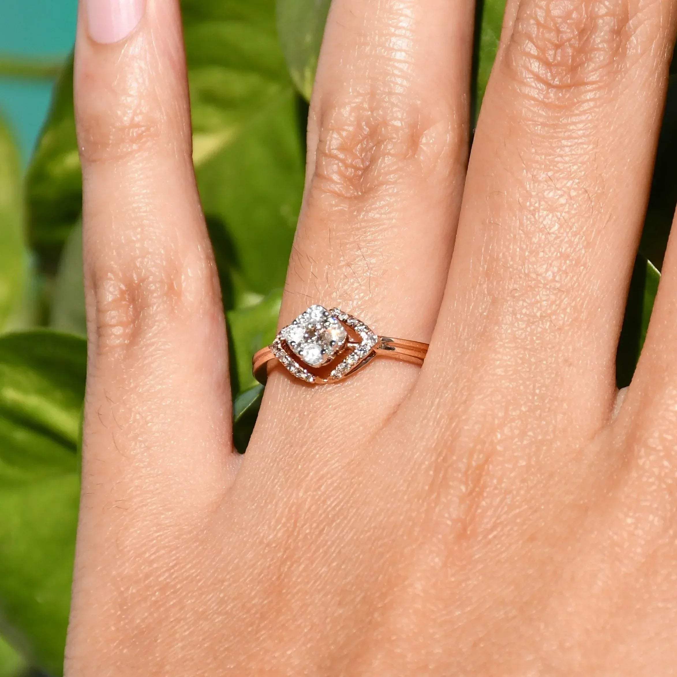 A person's hand displaying a gold ring with a central diamond surrounded by smaller diamonds set in a solid gold band.
