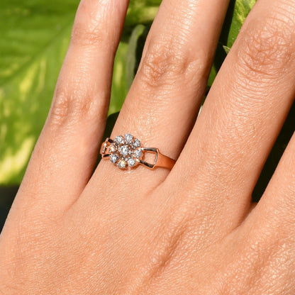 A person's hand displaying a 14K gold diamond band ring with a central row of diamonds and smaller surrounding diamonds set in a gold band.