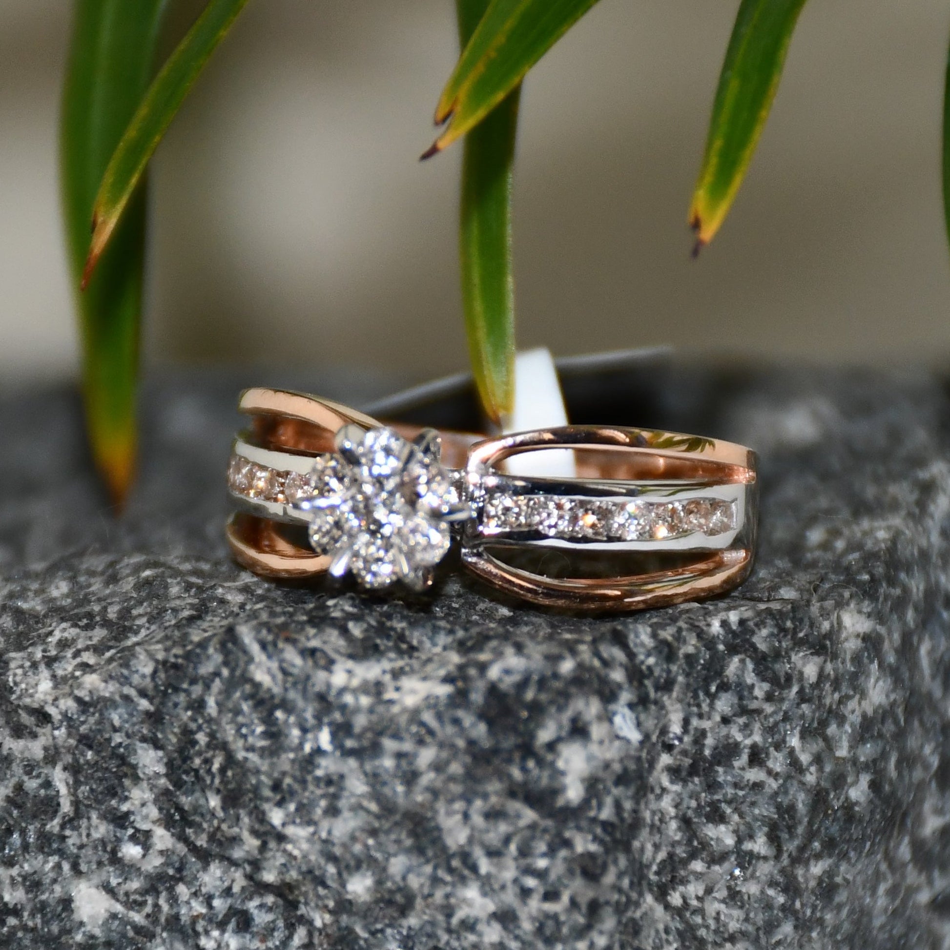A diamond band ring with 14K gold hallmark, displayed on a black and grey rough surface.