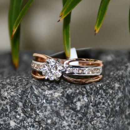 A diamond band ring with 14K gold hallmark, displayed on a black and grey rough surface.