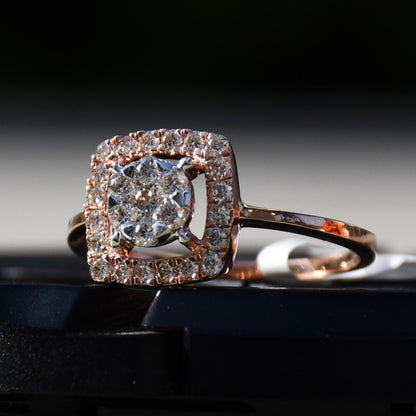 A gold band ring with a square-shaped, brilliant-cut diamonds centerpiece, set on a black surface.