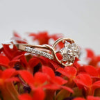 A 14kt gold diamond band ring with brilliant cut natural diamonds on red flowers.