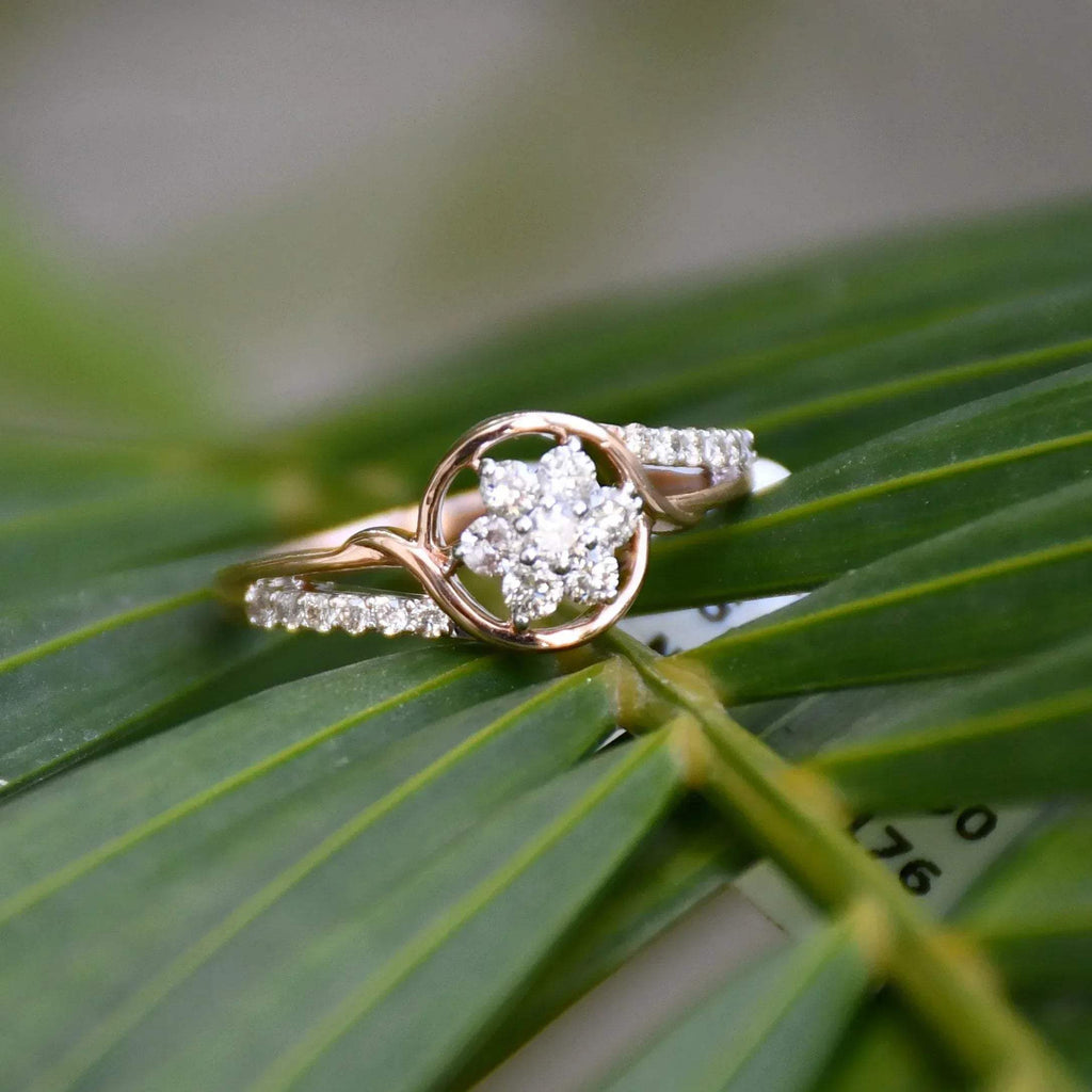 A 14kt gold diamond band ring with three brilliant cut natural diamonds on long green leaves.