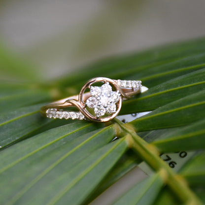 A 14kt gold diamond band ring with three brilliant cut natural diamonds on long green leaves.