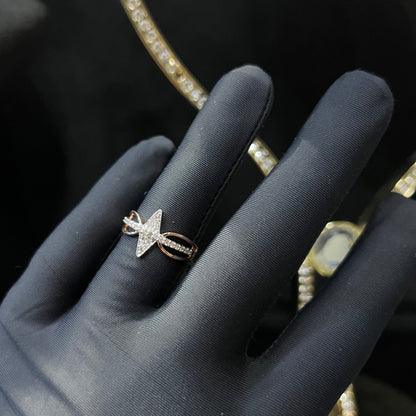 A handcrafted natural diamond solid gold ring, held in a gloved hand, featuring a brilliant cut diamond on a band with a star-shaped detail on the top.