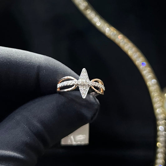 A handcrafted natural diamond solid gold ring, held in a gloved hand, featuring a brilliant cut diamond on a band with a star-shaped detail on the top.