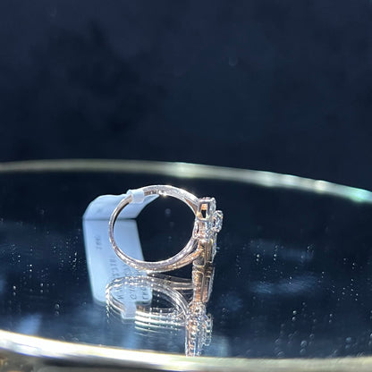 Elegant open-style diamond ring featuring a pear-shaped halo on one side and a square cluster on the other, worn in a black mannequin's hand displayed displayed against a reflective metallic background.