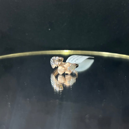 A ring with a gold band and a central natural diamonds, displayed on a reflective surface.