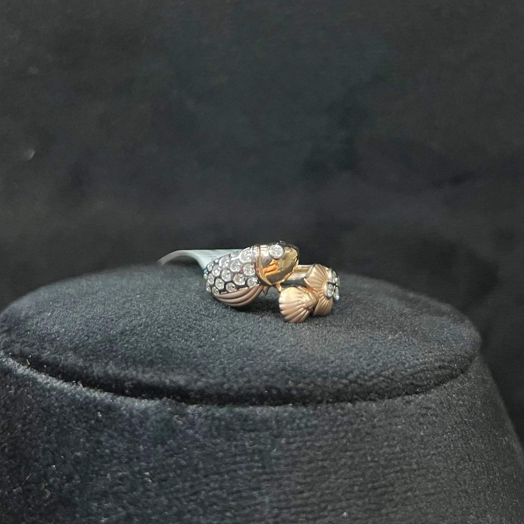 A ring with a gold band and a central natural diamonds, displayed on a black mannequin bust.