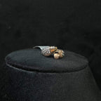 A ring with a gold band and a central natural diamonds, displayed on black mannequin bust.