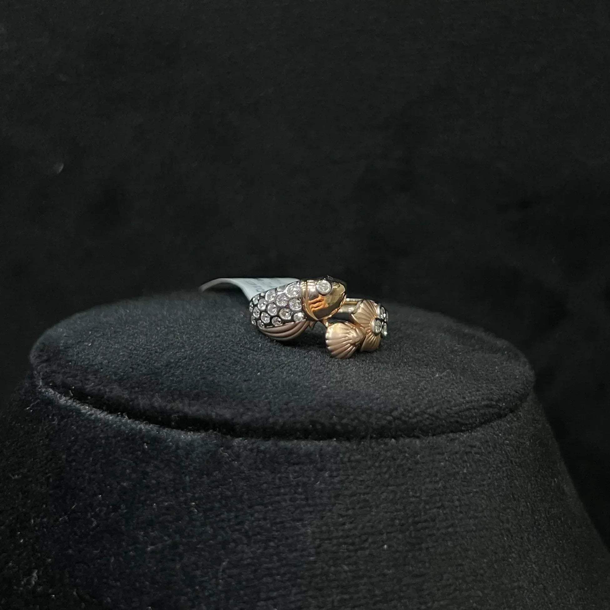 A ring with a gold band and a central natural diamonds, displayed on black mannequin bust.