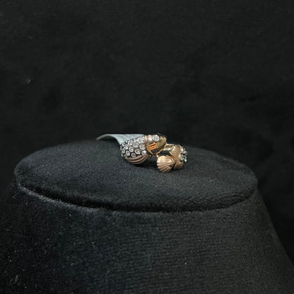 A ring with a gold band and a central natural diamonds, displayed on black mannequin bust.