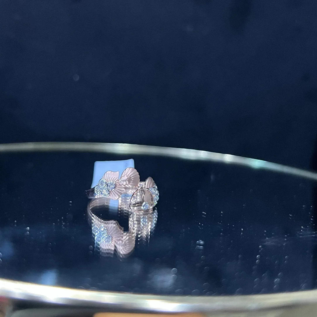 A ring with a gold band and a central natural diamonds, displayed on a reflective surface.