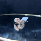 A ring with a gold band and a central natural diamonds, displayed on a reflective surface.