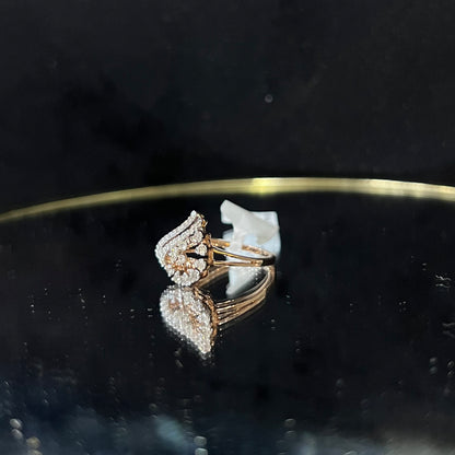 A handcrafted natural diamond solid gold ring displayed on a reflective surface, with a brilliant cut diamond in a gold band.