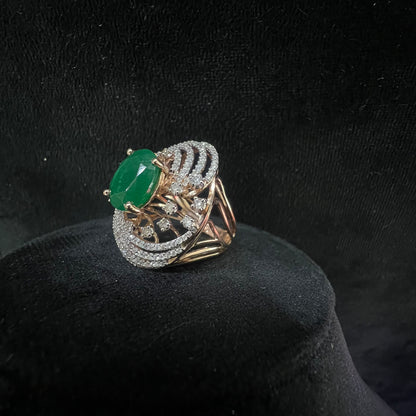 Close-up of an elegant statement ring featuring a large oval green gemstone at the center, surrounded by concentric circles of sparkling white diamonds set in a gold base against a black background.