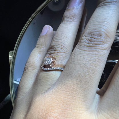 A person's hand displaying a gold band ring with a central natural diamond, surrounded by smaller clear stones.