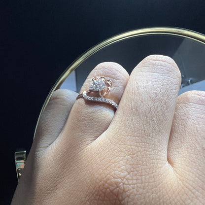 A person's hand displaying a gold band ring with a central natural diamond, surrounded by smaller clear stones.