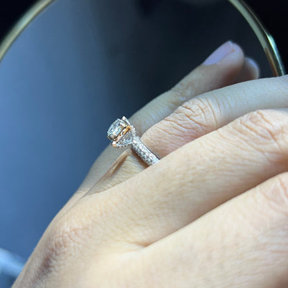 A person's hand displaying a solitaire diamond band ring on their finger.