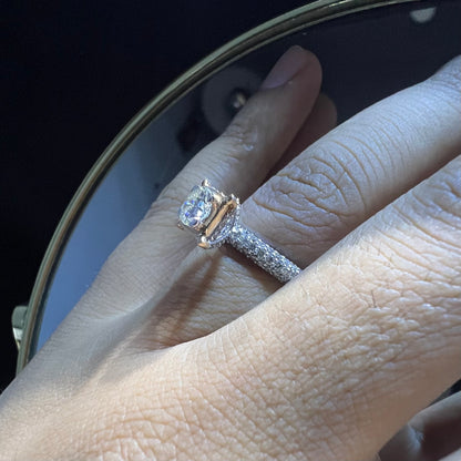 A person's hand displaying a solitaire diamond band ring on their finger.