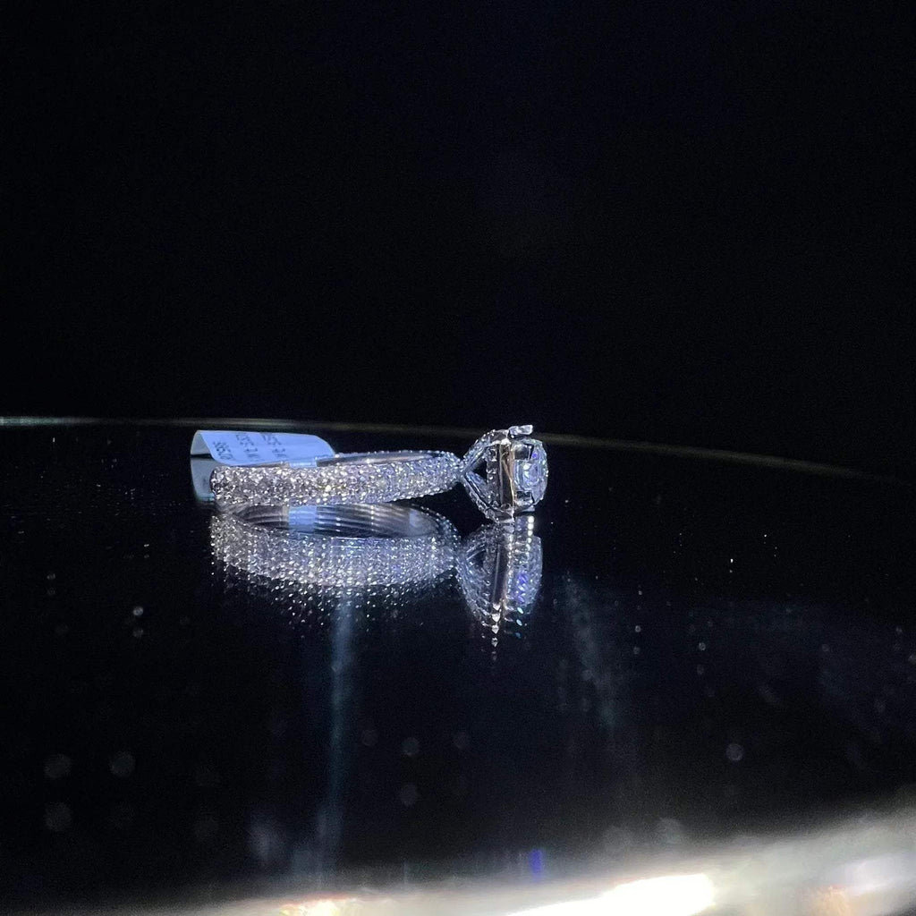 A a solitaire diamond band ring, displayed on a reflective surface.