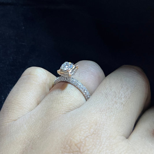A person's hand displaying a solitaire diamond band ring on their finger.