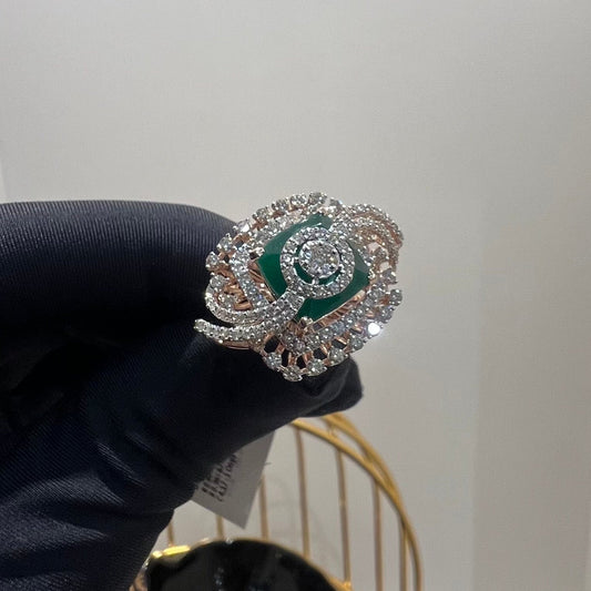 A handcrafted natural diamond solid gold ring held in a person's hand, with a green gemstone and intricate gold detailing.