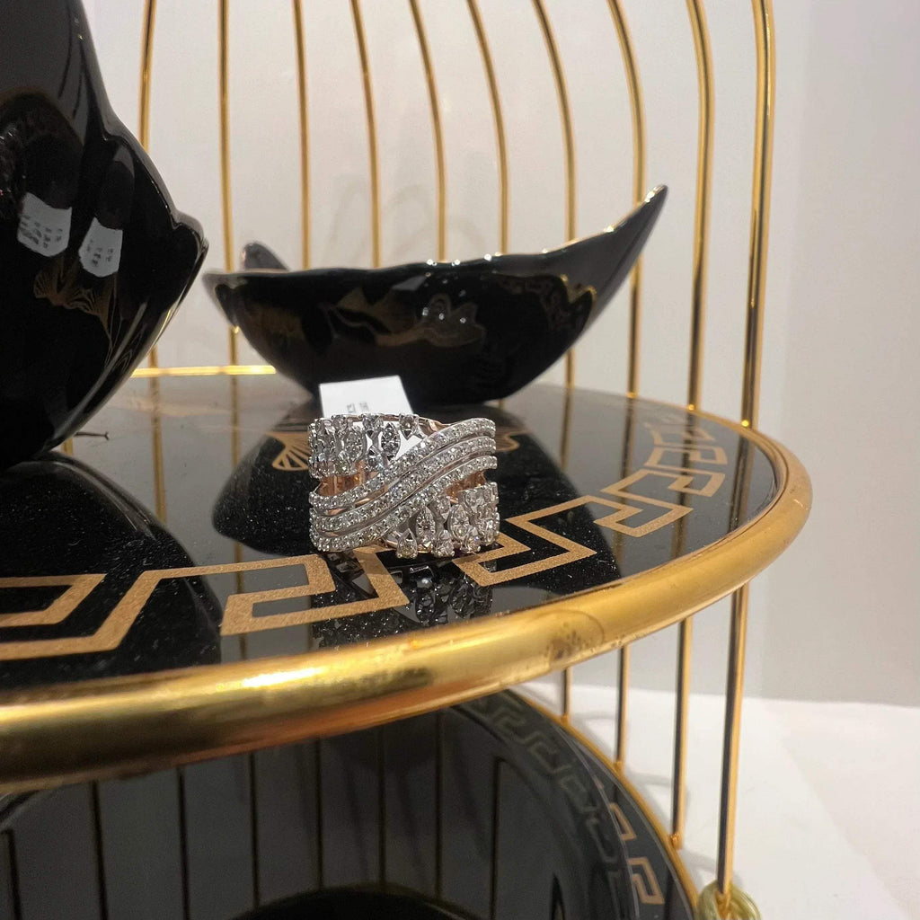 Close-up of an elegant wide diamond ring, featuring multiple crisscrossing bands adorned with round-cut diamonds set in gold, displayed on a black reflective surface.