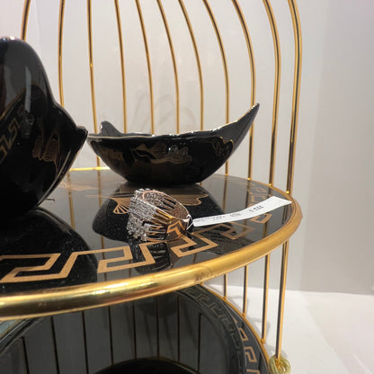 Close-up of an elegant wide diamond ring, featuring multiple crisscrossing bands adorned with round-cut diamonds set in gold, displayed on a black reflective surface.